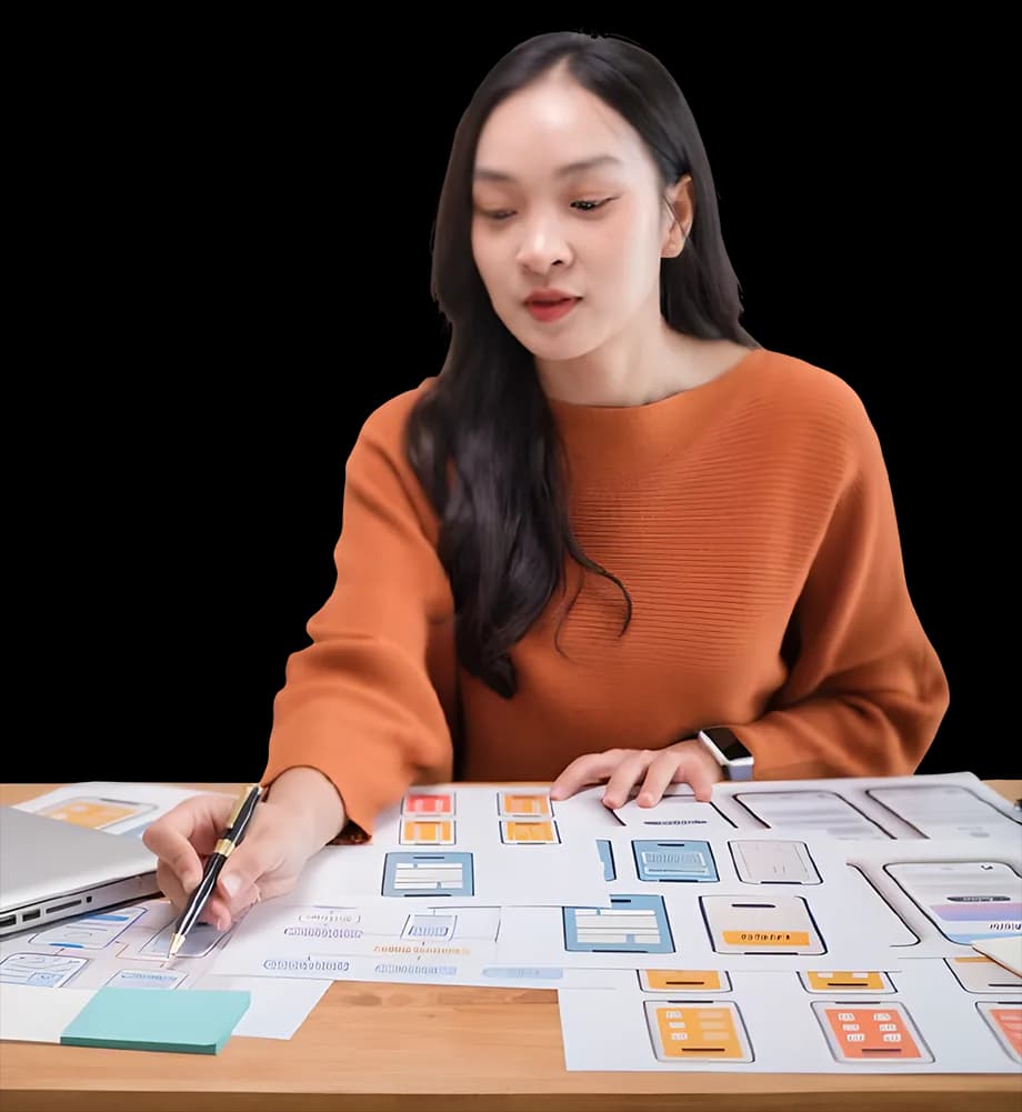 A designer reviewing website wireframes at her desk