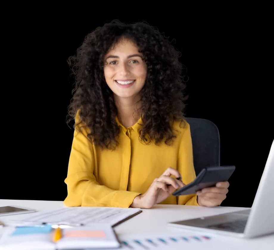 A woman at her desk working through figures on a calculator